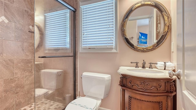 bathroom with toilet, a stall shower, and vanity