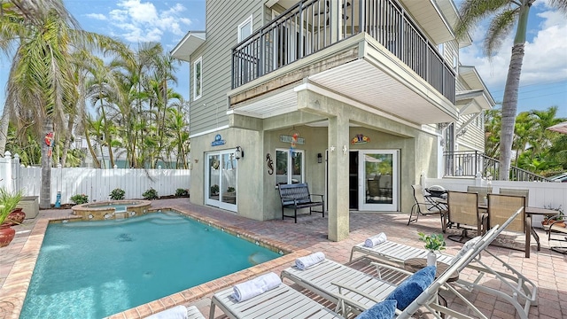 back of property featuring a balcony, a fenced backyard, stucco siding, and a patio area
