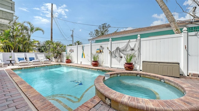 view of swimming pool featuring a fenced backyard and a pool with connected hot tub