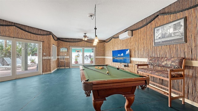 recreation room with finished concrete flooring, healthy amount of natural light, ceiling fan, wooden walls, and billiards table