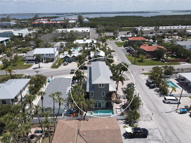 aerial perspective of suburban area with a pool and a nearby body of water