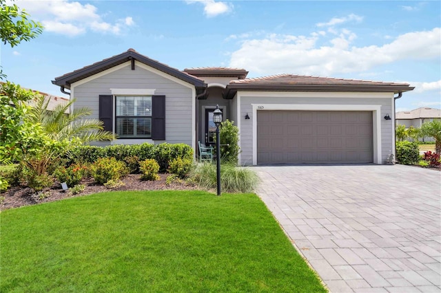 5165 Coral Reef Way, Bradenton, FL 34211 - view of front facade with a front yard, decorative driveway, a tiled roof, and a garage