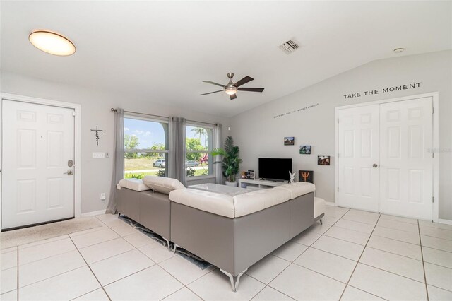 living area with vaulted ceiling, a ceiling fan, light tile patterned floors, and baseboards
