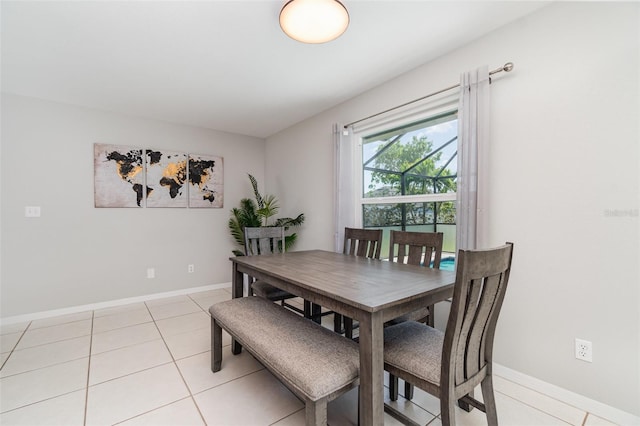 dining space with baseboards and light tile patterned flooring