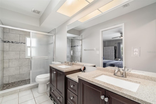 ensuite bathroom featuring a shower stall, toilet, tile patterned flooring, and two vanities