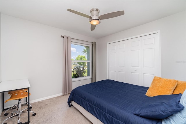bedroom featuring light carpet, baseboards, ceiling fan, and a closet