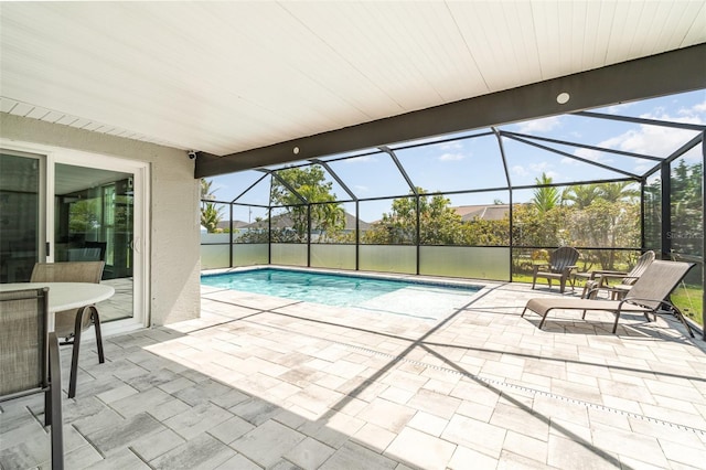 outdoor pool with a patio area and glass enclosure