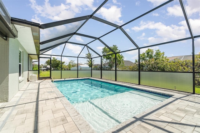 swimming pool featuring a patio area and glass enclosure