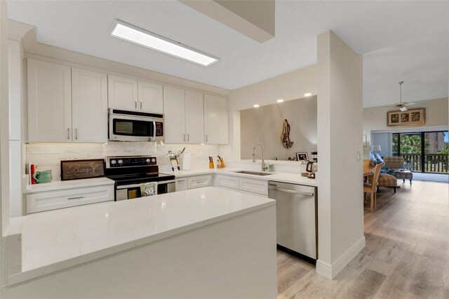 5632 Ashton Lake Dr Unit 5632, Sarasota, FL 34231 - kitchen with stainless steel appliances, a sink, light wood-style floors, decorative backsplash, and a ceiling fan