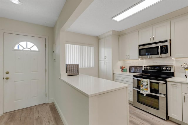5632 Ashton Lake Dr Unit 5632, Sarasota, FL 34231 - kitchen with stainless steel appliances, light wood finished floors, light countertops, and backsplash