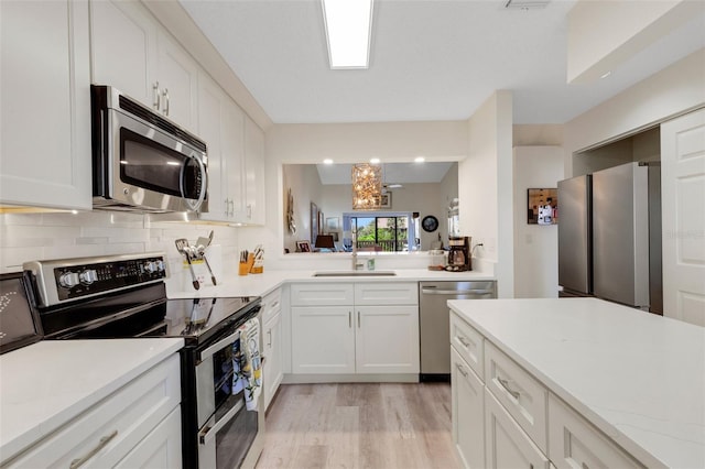 5632 Ashton Lake Dr Unit 5632, Sarasota, FL 34231 - kitchen with appliances with stainless steel finishes, a sink, light countertops, light wood-style floors, and backsplash