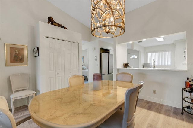 5632 Ashton Lake Dr Unit 5632, Sarasota, FL 34231 - dining space with light wood-style flooring, a chandelier, baseboards, and a high ceiling