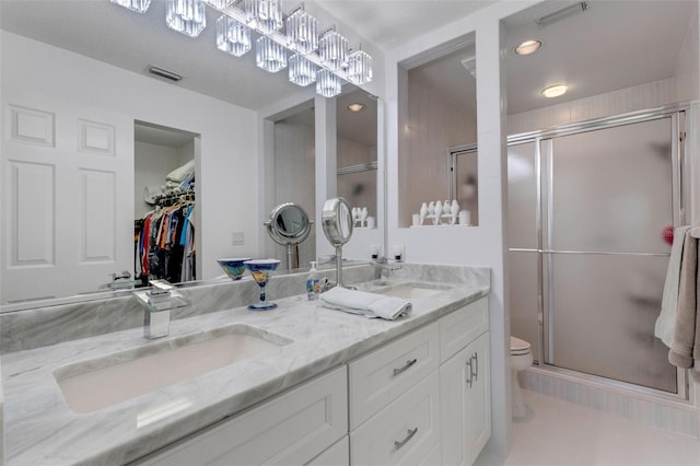 5632 Ashton Lake Dr Unit 5632, Sarasota, FL 34231 - bathroom featuring a stall shower, double vanity, toilet, and a spacious closet