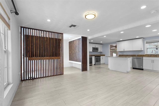 3616 Stardust Pl, Sarasota, FL 34232 - kitchen with stainless steel appliances, white cabinets, baseboards, light wood-style flooring, and recessed lighting