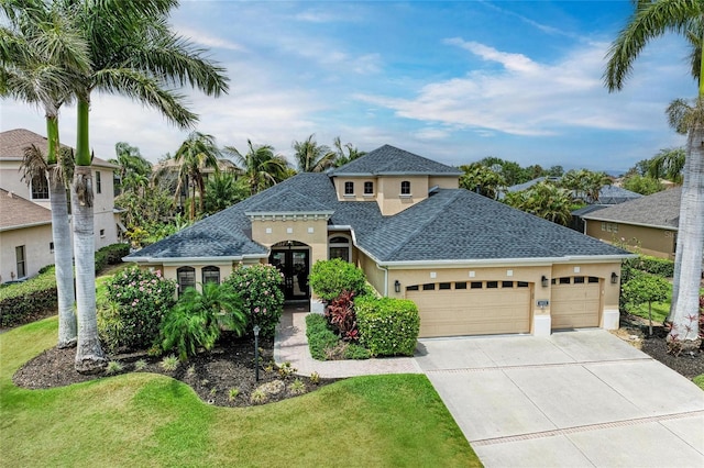 6674 Coopers Hawk Ct, Lakewood Ranch, FL 34202 - view of front of home with roof with shingles, a garage, stucco siding, concrete driveway, and a front lawn