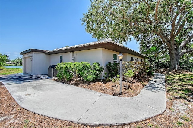 415 Courbet Dr Unit 415, Nokomis, FL 34275 - view of side of property with a garage, central air condition unit, and driveway