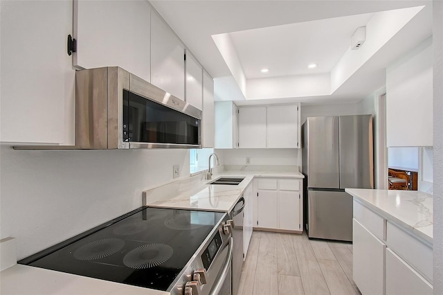 415 Courbet Dr Unit 415, Nokomis, FL 34275 - kitchen with stainless steel appliances, a sink, a raised ceiling, white cabinetry, and recessed lighting