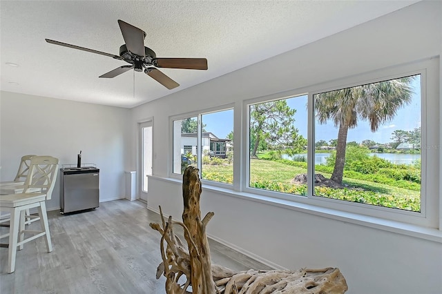 415 Courbet Dr Unit 415, Nokomis, FL 34275 - dining room with ceiling fan, baseboards, a water view, light wood-style floors, and a textured ceiling