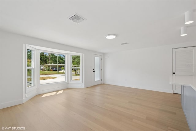 2655 Bay St, Sarasota, FL 34237 - unfurnished living room with baseboards, visible vents, and light wood-style floors
