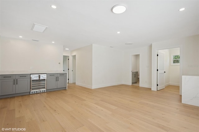 2655 Bay St, Sarasota, FL 34237 - empty room with beverage cooler, light wood finished floors, bar, baseboards, and recessed lighting