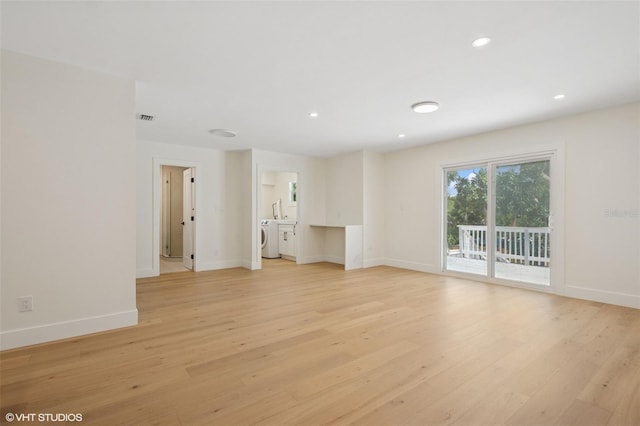 2655 Bay St, Sarasota, FL 34237 - unfurnished living room with washing machine and dryer, baseboards, visible vents, and light wood-style floors