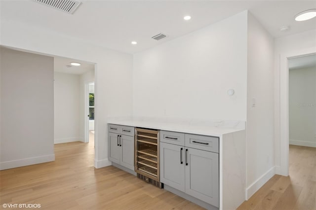 2655 Bay St, Sarasota, FL 34237 - bar with light wood finished floors, beverage cooler, visible vents, and baseboards