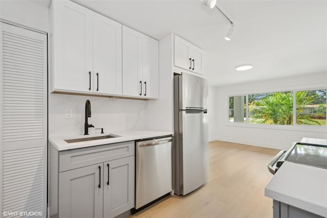 2655 Bay St, Sarasota, FL 34237 - kitchen with stainless steel appliances, a sink, light countertops, light wood-style flooring, and baseboards