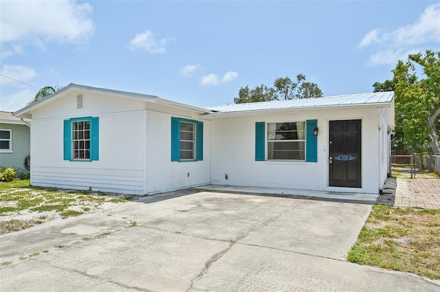 view of front of house with metal roof and fence