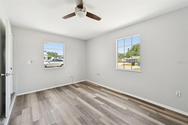 empty room featuring a ceiling fan, wood finished floors, and baseboards