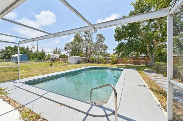 view of pool with a shed and an outbuilding