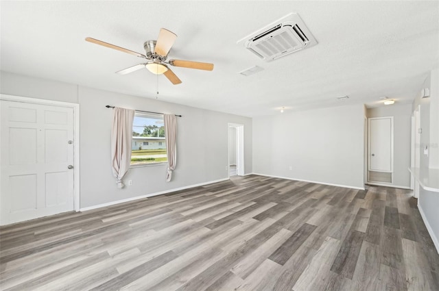 unfurnished living room with wood finished floors, a ceiling fan, and baseboards