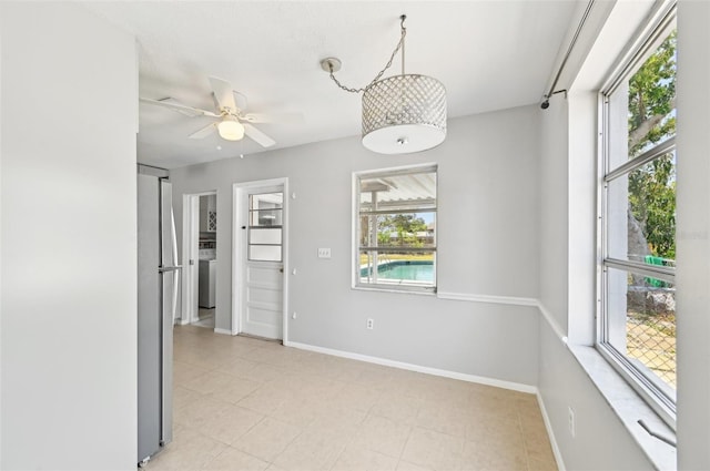 unfurnished room featuring ceiling fan and baseboards