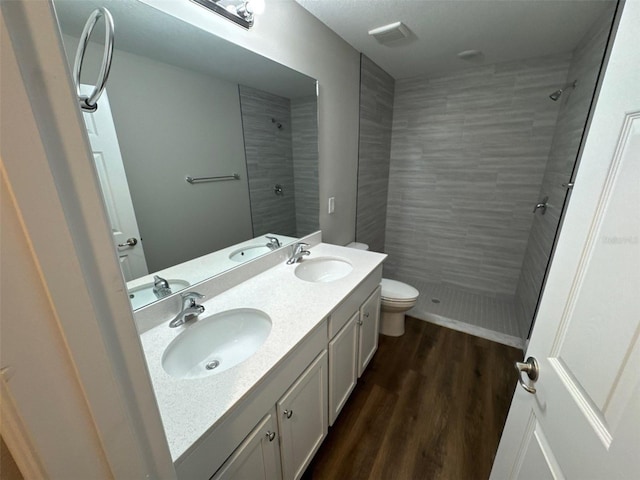 3180 Lakeland Ave SW, Palm Bay, FL 32908 - full bathroom with tiled shower, toilet, double vanity, and wood finished floors