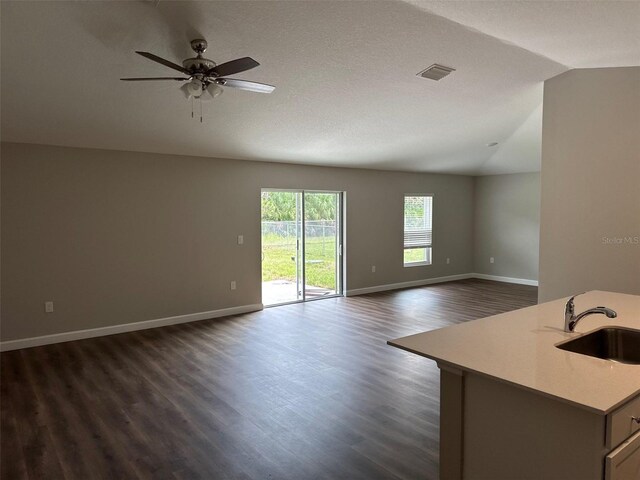 3180 Lakeland Ave SW, Palm Bay, FL 32908 - unfurnished living room with vaulted ceiling, a sink, dark wood finished floors, a ceiling fan, and baseboards
