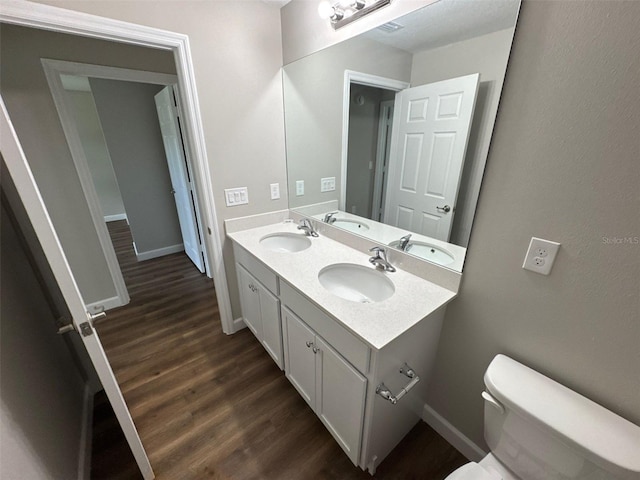 3180 Lakeland Ave SW, Palm Bay, FL 32908 - bathroom with wood finished floors, double vanity, toilet, and baseboards