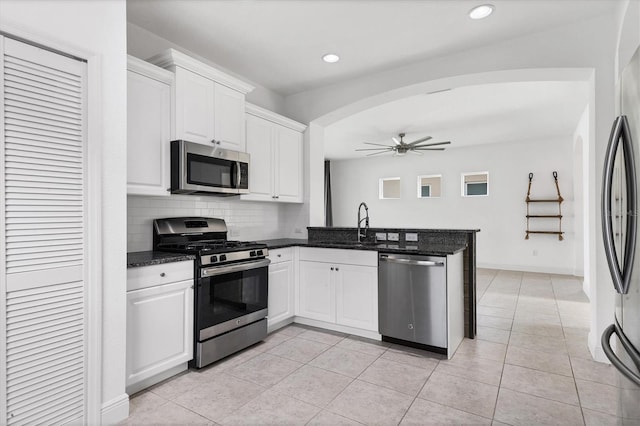 4315 Deep Creek Ter, Parrish, FL 34219 - kitchen with stainless steel appliances, a peninsula, a ceiling fan, arched walkways, and white cabinetry