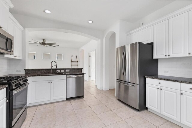 4315 Deep Creek Ter, Parrish, FL 34219 - kitchen featuring appliances with stainless steel finishes, arched walkways, white cabinets, a ceiling fan, and backsplash