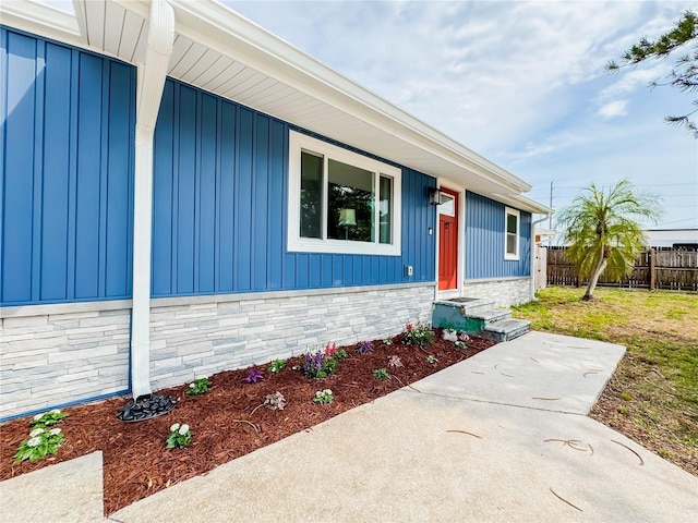 view of front of home with board and batten siding and fence
