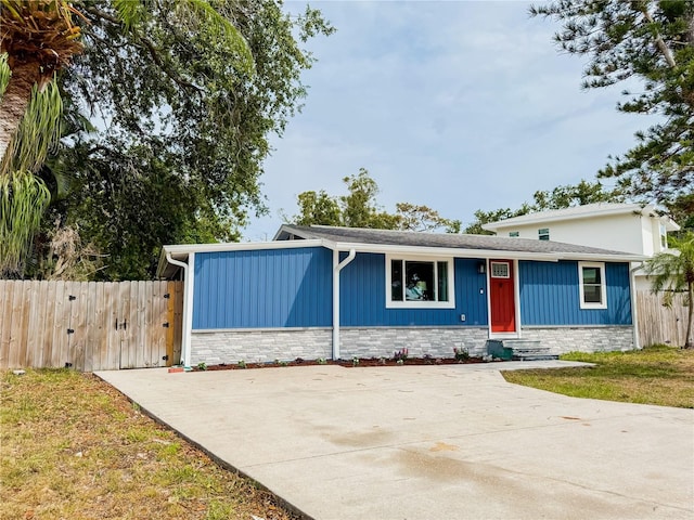 view of front facade with entry steps, fence, and board and batten siding