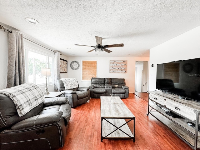 living area with a textured ceiling, wood finished floors, and a ceiling fan
