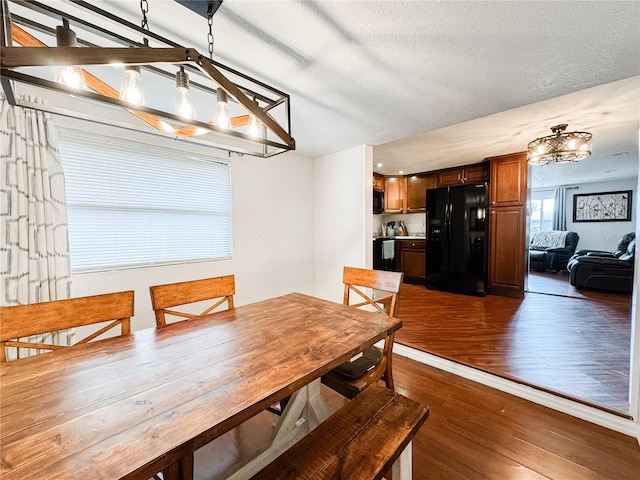 dining space featuring hardwood / wood-style flooring, a chandelier, and a textured ceiling