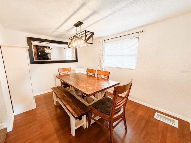 dining area featuring wood finished floors, baseboards, and a chandelier