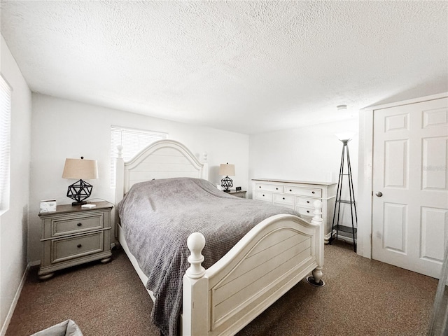 bedroom with carpet, a textured ceiling, and baseboards