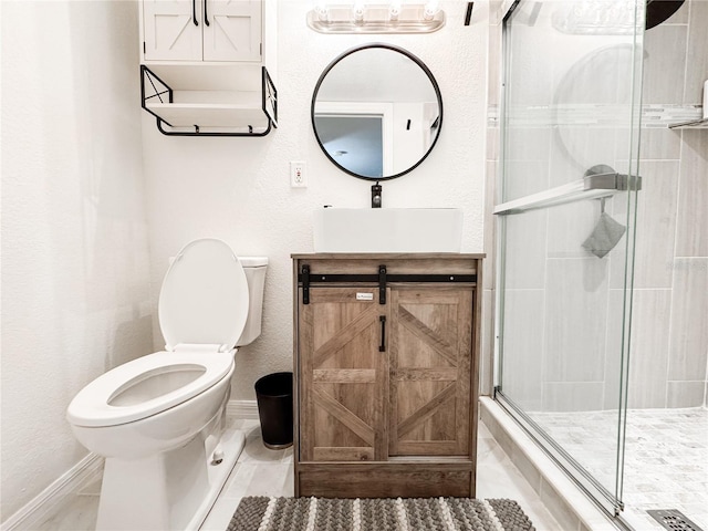 bathroom featuring toilet, a shower stall, baseboards, and vanity