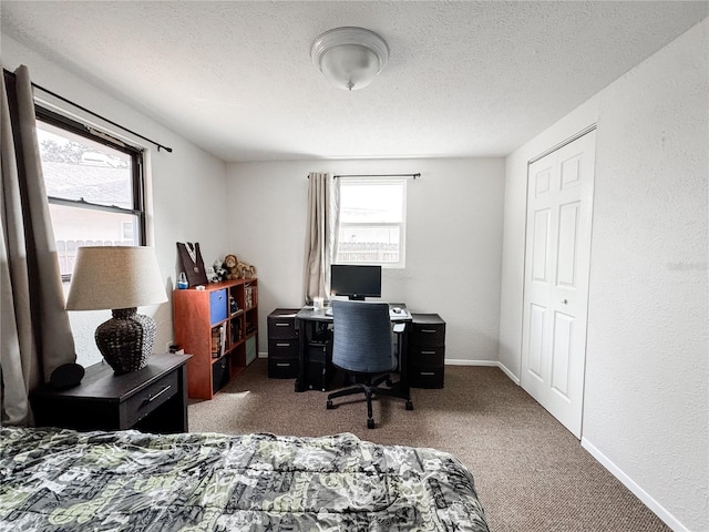 office area with carpet floors, a textured ceiling, and baseboards