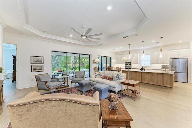 living room with crown molding, plenty of natural light, light wood-style floors, a ceiling fan, and recessed lighting