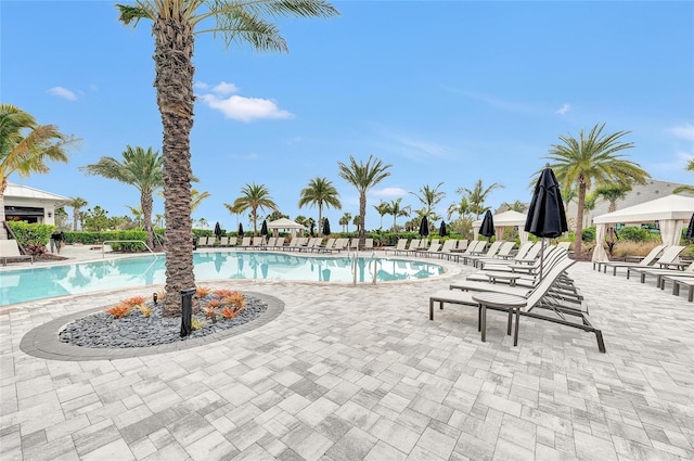 community pool with a gazebo and a patio