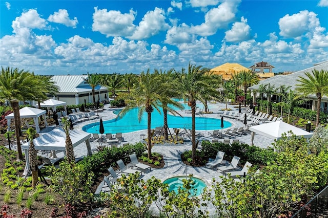 community pool with a patio and a community hot tub