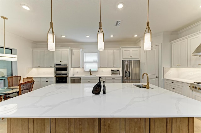 kitchen with stainless steel appliances, a sink, a large island, ornamental molding, and backsplash
