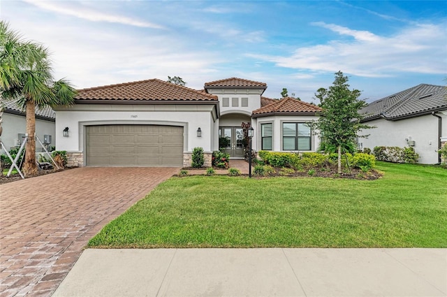 mediterranean / spanish-style house with french doors, stucco siding, decorative driveway, and a garage